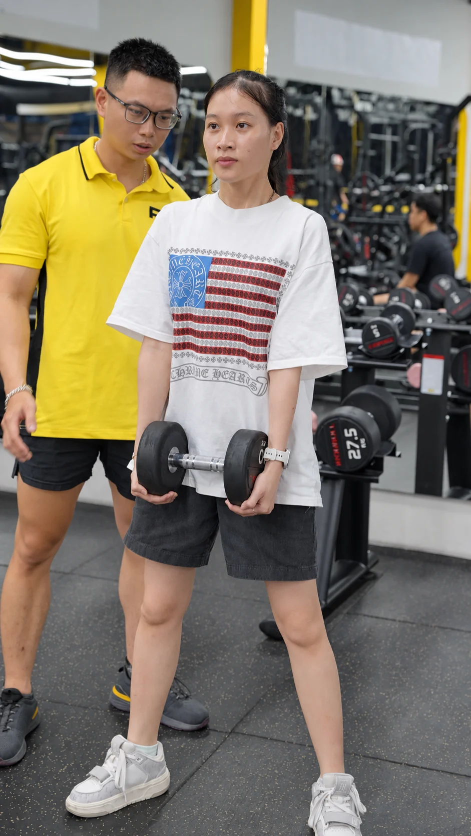 Nữ hội viên tập tạ cùng huấn luyện viên tại Dũng Gym Fitness 3