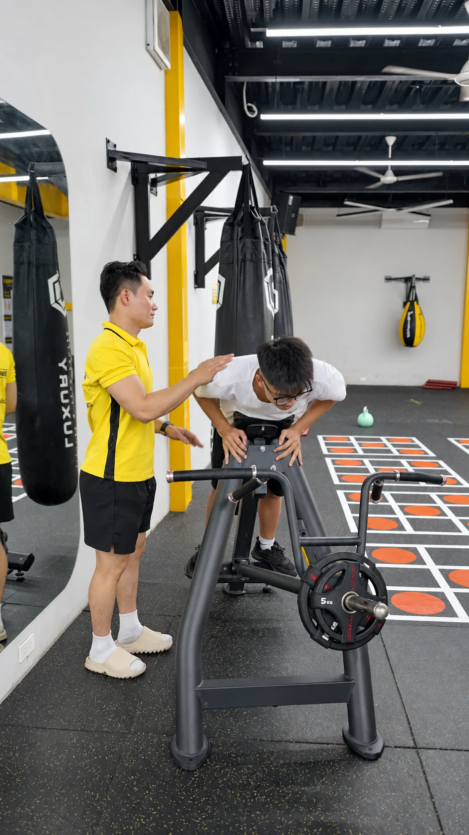 Huấn luyện viên áo vàng hướng dẫn tập tại Dũng Gym 3